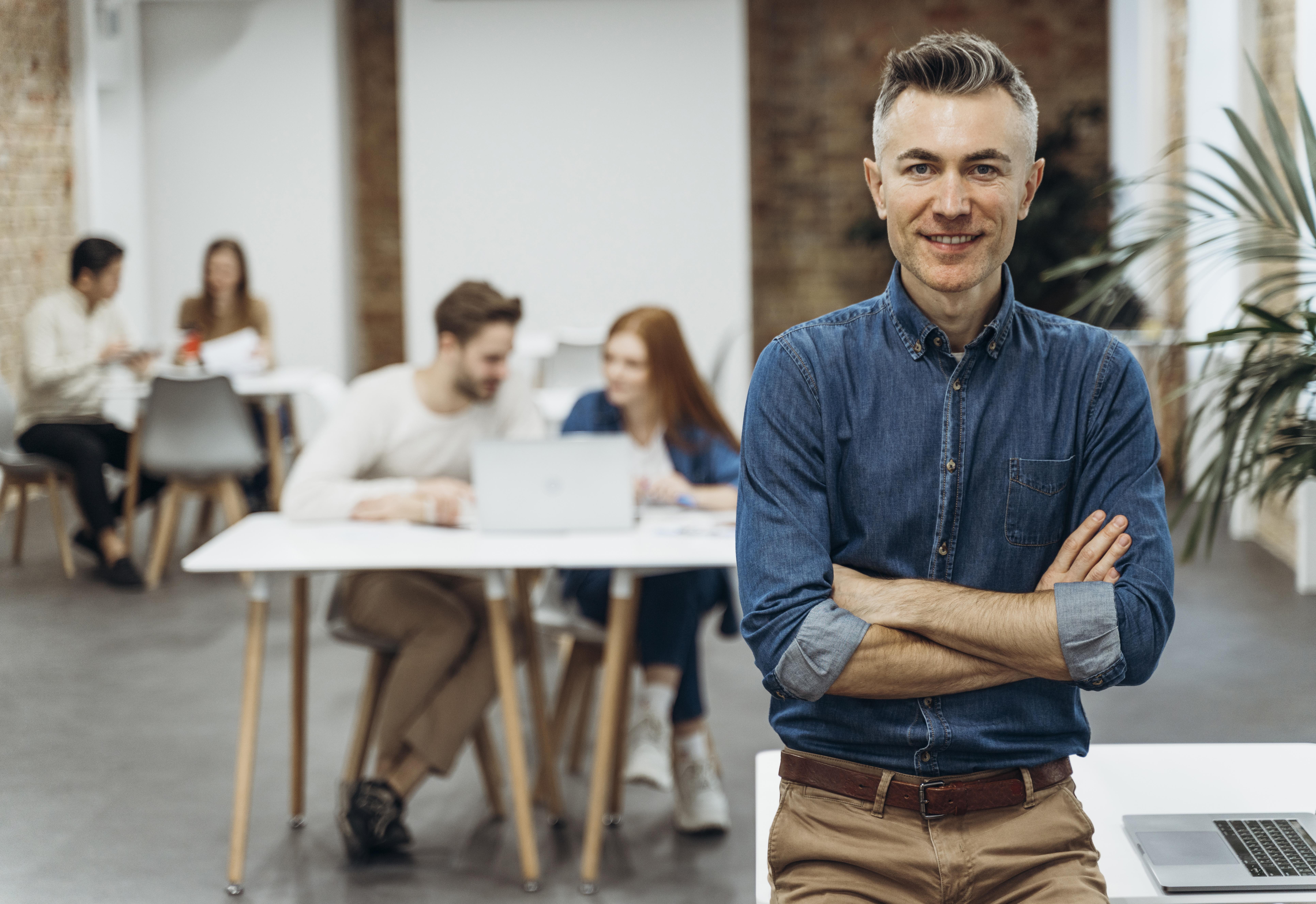 man-with-laptop-posing-coworkers